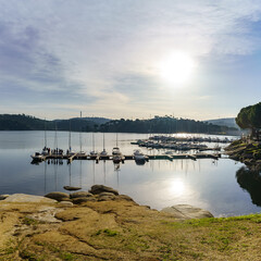 People learning to sail on a sailing boat with a teacher teaching the lesson in the San Juan reservoir in Madrid.