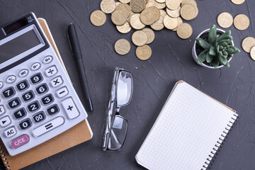 Calculator keypad on a beton floor background. Top view. Copy space.Notebook, pen, glasses And a small artificial plant.