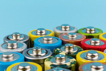 Photo of alkaline batteries on blue background. Recycling of rechargeable NiMH batteries. The...
