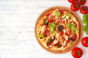 Pizza with ham and salad on wooden background