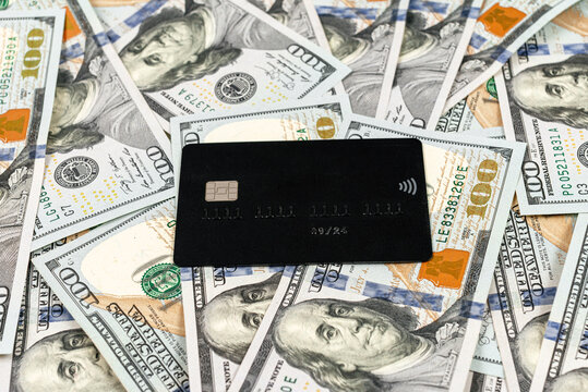Black credit card on money background. Credit card on dollar bills as wealthy concept