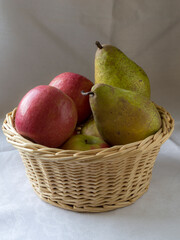 A wicker basket filled with apples and pears