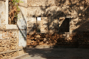 View to ruined natural stone building. Alleyway at historic turkish town. Ancient architecture background.