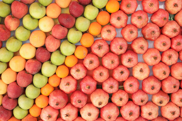Mixed colorful fruits background. Top view of beautifully arranged apples, tangerines and pomegranate fruits. Healthy food concept.