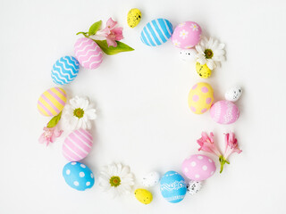 Obraz na płótnie Canvas Easter banner. Round frame. Spring holiday decoration. Gift card. Pastel color blue pink yellow painted eggs with minimal pattern flower circle wreath composition isolated on white empty space.
