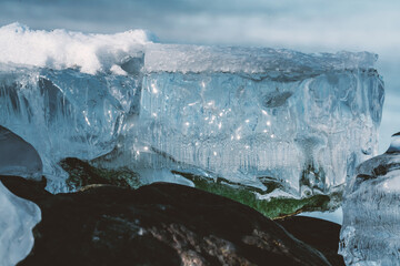 Glacial ice melting away revealing rocks and boulders beneath.