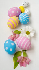 Fototapeta na wymiar Easter decoration. Holiday ornament. Floral composition. Colorful pink blue yellow painted eggs with stripe polka dot creative pattern Spring flowers set isolated on white background.