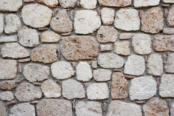 Blocks of an ancient castle surface. Rough weathered ancient stone wall surface texture.