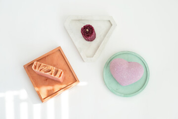 Beauty, spa and wellness concept - close up of soap, candle and bath bomb on gypsum tray. DIY soap, wax candle, bath bomb.  