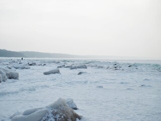 At the beach during winter by the frozen sea.