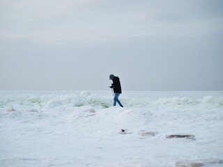 At the beach during winter by the frozen sea.