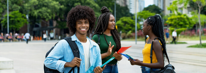 Young afro american male student with group of young adults