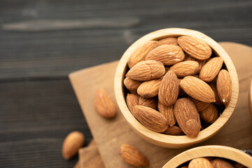 Bowl with almond on a wooden table. (selective focus; close-up shot)
