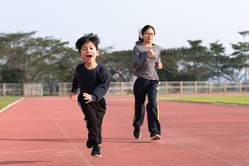Asian mother running with her son
