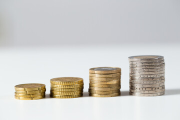 Pile of euro coins prospering on white background. Golden money cash growing in steps. Concept of investment increasing value over time from close-up.
