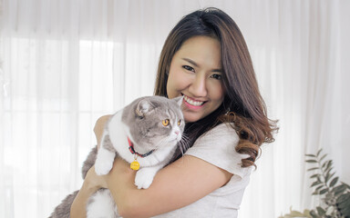 Asian woman smiling and hug her cat