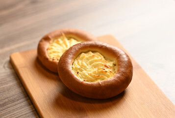 Two rolls with cottage cheese on a cutting board. Image with selective focus.