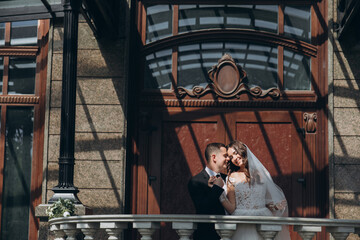 Fototapeta na wymiar Groom hugs bride from behind standing in the greenhouse