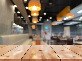 Empty wooden table top with lights bokeh on blur restaurant background.