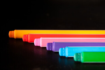 Colorful pens on black background