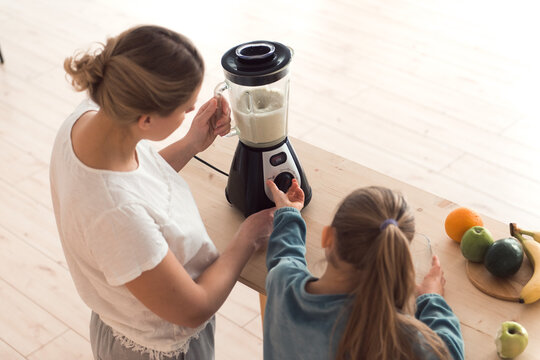 Mom and daughter make fresh smoothie in blender, healthy food lifestyle, top view, high angle