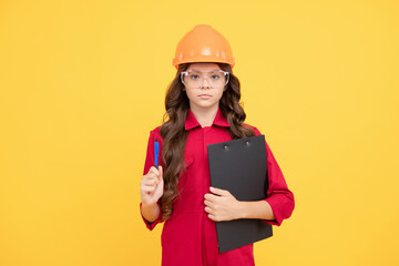 serious child girl in protective hard hat and glasses hold folder with paper documents, expert