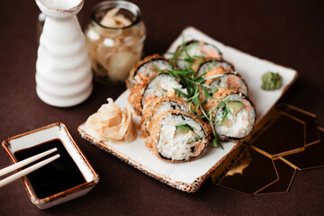 Large rolls with avocado and salmon on a white clay plate