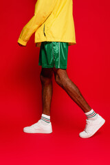 cropped view of stylish african american man walking on red