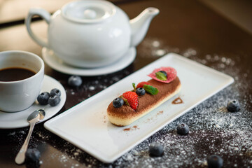 Delicious dessert tiramisu with strawberries and blackberries