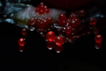 Wine for two red eggs on a background of ice and caviar. Black background.