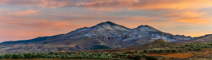 valley and peak of snow-capped mountain at sunset, hairy colors of the sunset.