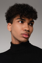 Obraz premium young african american man in black turtleneck sweater looking away isolated on gray