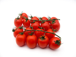 Small red fresh cherry tomatoes on a branch on a white background.