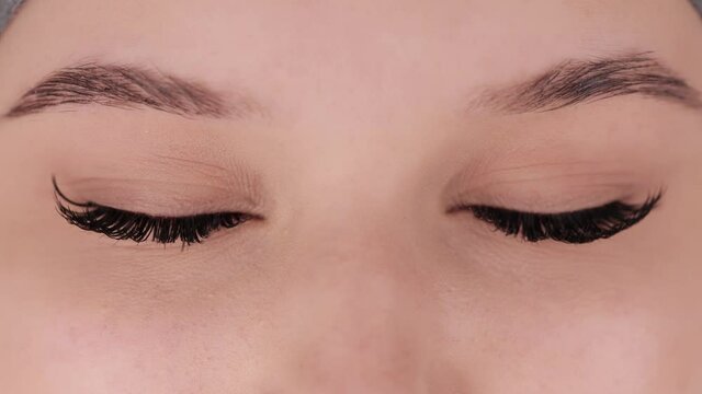 Close up portrait of female eyes after eyelash extension procedure. Young girl open eyes with fake eyelashes. Eyelashes extensions close up.