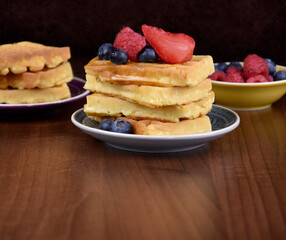 Homemade traditional belgian waffles with fresh fruits berries frame stock images. Fresh waffles with strawberries, raspberries and blueberries on a wooden background with copy space for text