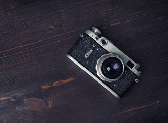 Old vintage camera on wood table background. Flat lay.