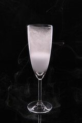 Glass wine goblet filled with smoke on a black background with reflection. High quality photo