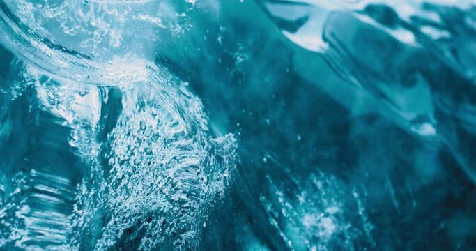 Deeply blue ice forming glacial ice cave slowly melting down in Iceland in winter 4K