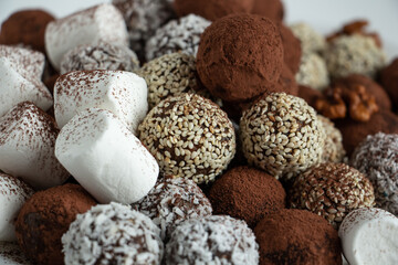 Fototapeta na wymiar truffles with cocoa, coconut and sesame seeds with chocolate and marshmallows, delicious dessert