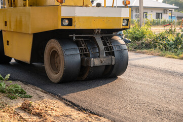 Heavy vibration yellow steamroller or soil compactor working on hot-mix asphalt pavement road