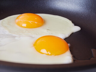 Scrambled eggs in an iron pan on the rustic wooden table