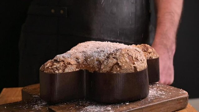 Traditional Italian desserts for Easter - Easter dove . Man holding sweet festive pastries with almonds in his hands. Dark footage. Slomoushe. High quality FullHD footage