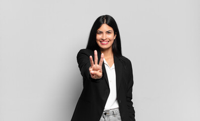young hispanic businesswoman smiling and looking friendly, showing number three or third with hand...