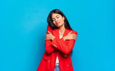 young hispanic businesswoman feeling in love, smiling, cuddling and hugging self, staying single,...