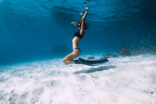 Woman freediver posing over sandy sea. Freediving underwater in Hawaii