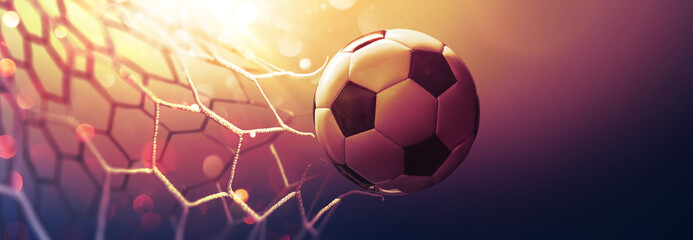 Fototapeta Soccer ball in the net in the sunbeams. Golden background obraz