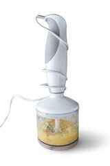 Using blender for making a healthy smoothie or juice or jam.  Hand blender isolated on white background.