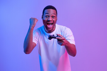 Overjoyed Black Man With Joystick In Hand Celebrating Win In Video Game