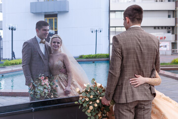 A young couple is walking around the city. The bride and groom are walking.