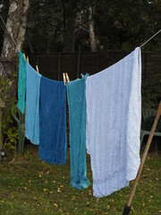 some bath towels hanging out to dry on a garden washing line